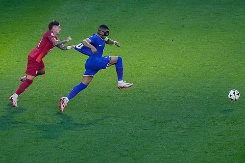 Kylian Mbappe is tackled by Nicola Zalewski